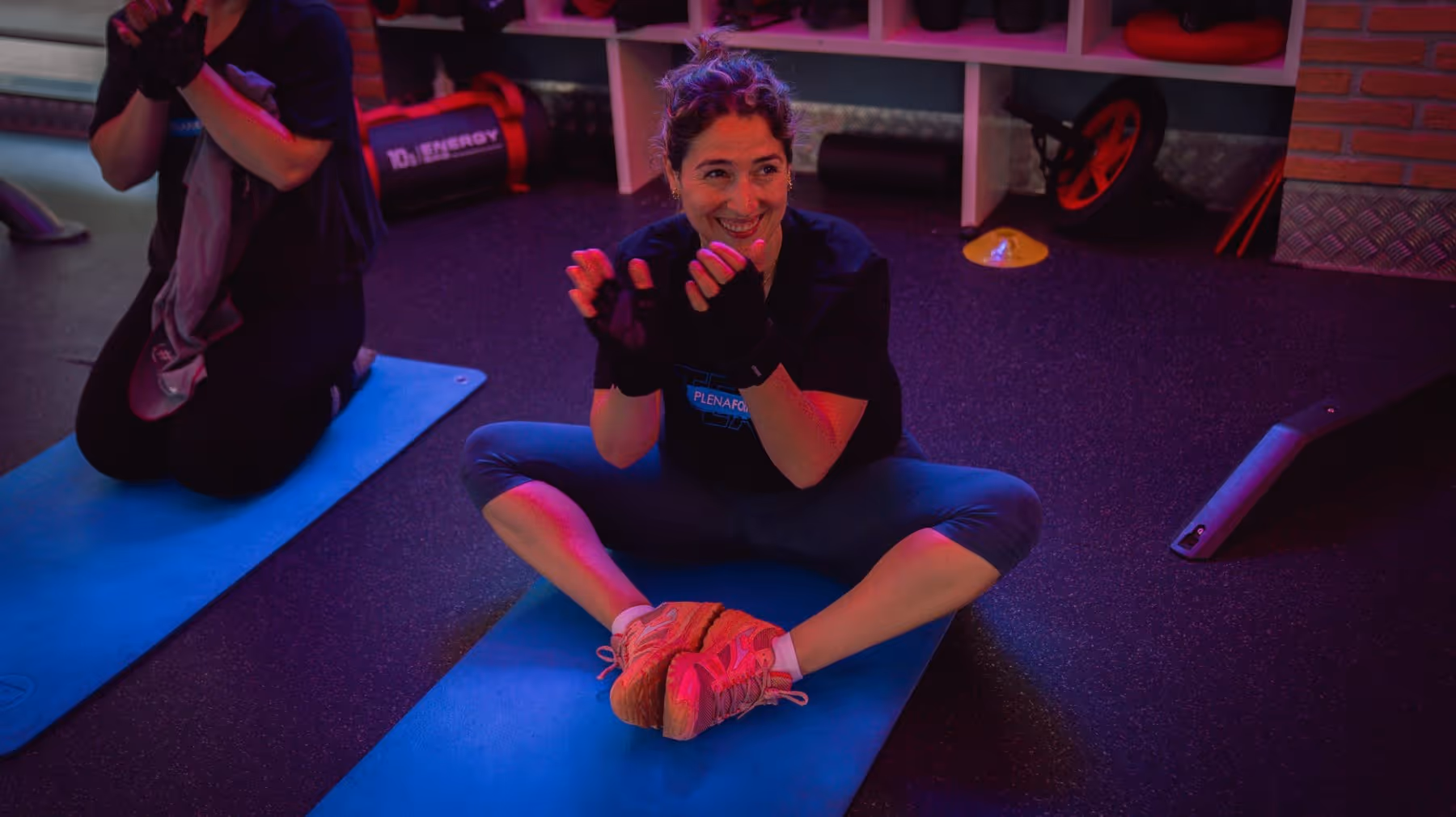 Clienta sonriendo sentada en una esterilla durante la vuelta a la calma
